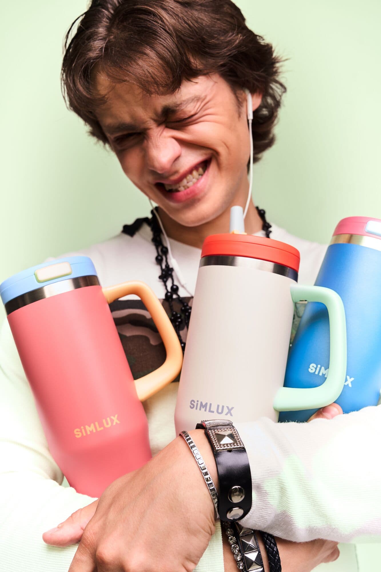 Model hugging SiMLUX tumblers in Candy Pink, Cream and Deep Blue