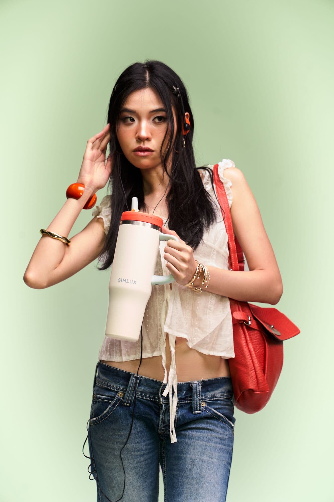 Full-length portrait with a Cream 40oz tumbler and red bag