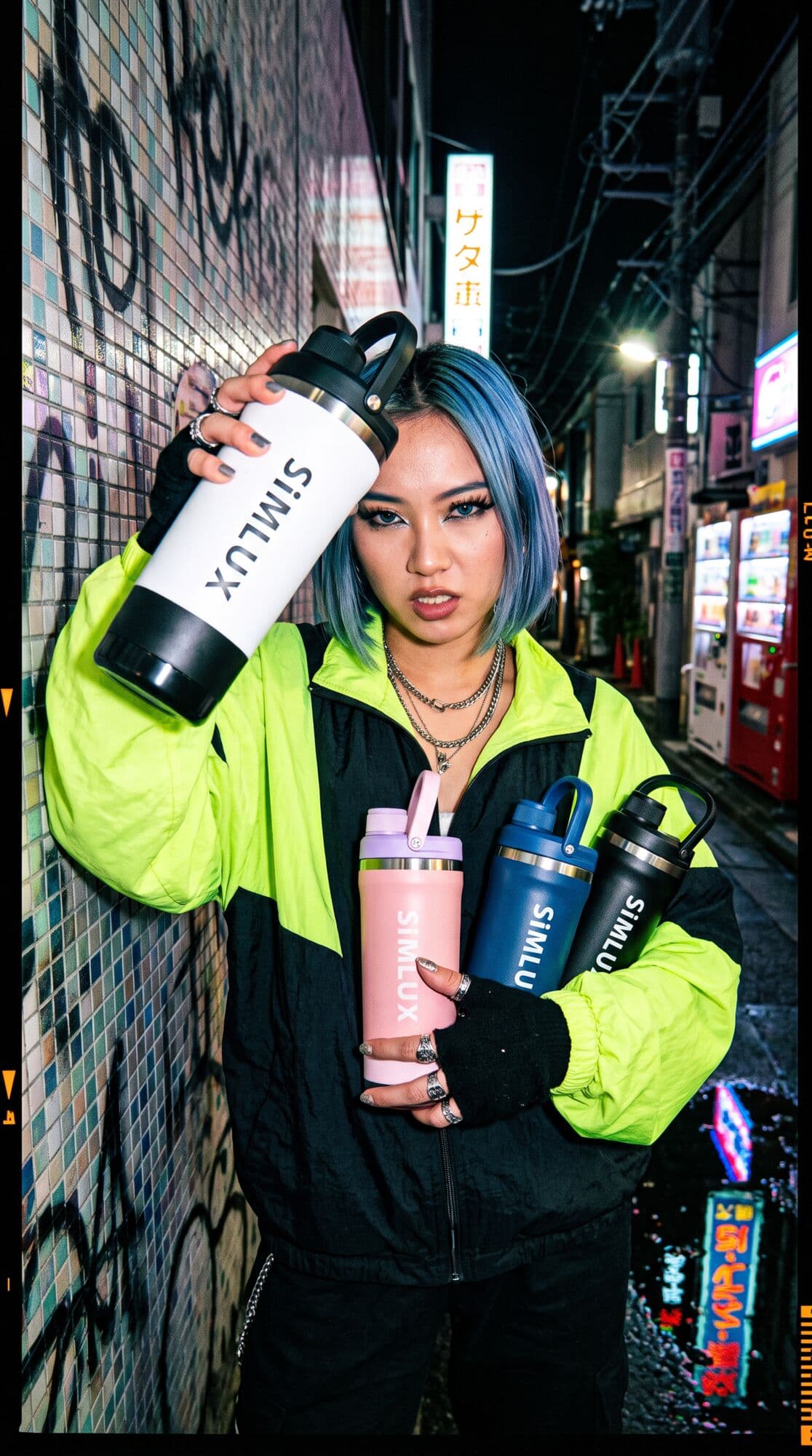 Model with blue hair and a neon jacket holding a White shaker on a neon-lit street