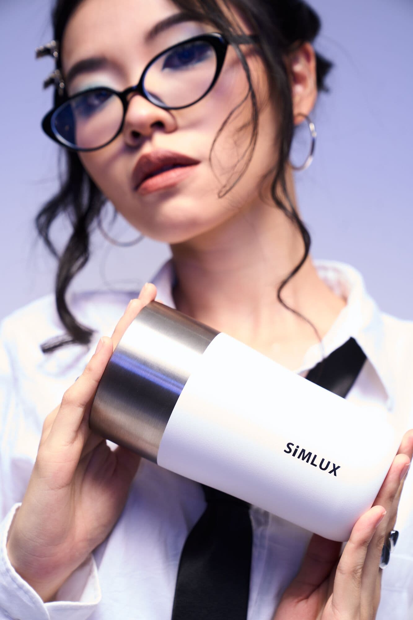 Model holding a white coffee tumbler